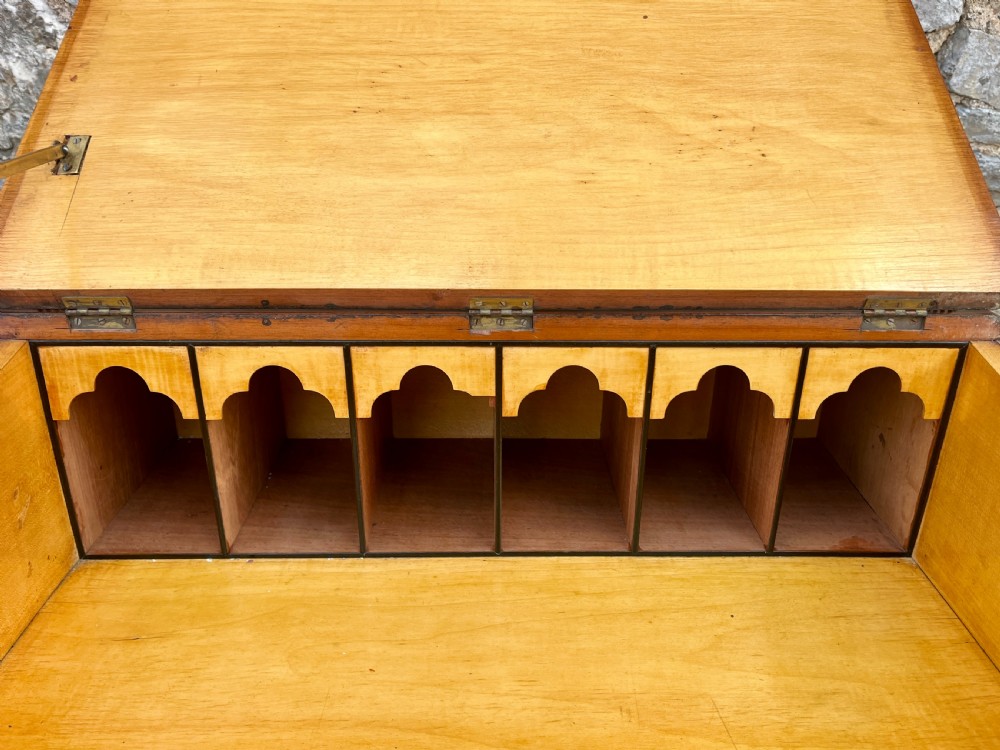 A Victorian mahogany Davenport desk featuring a sloped leather writing surface, side drawers with turned wooden knobs, a top brass gallery rail, and carved scroll front supports. View VII