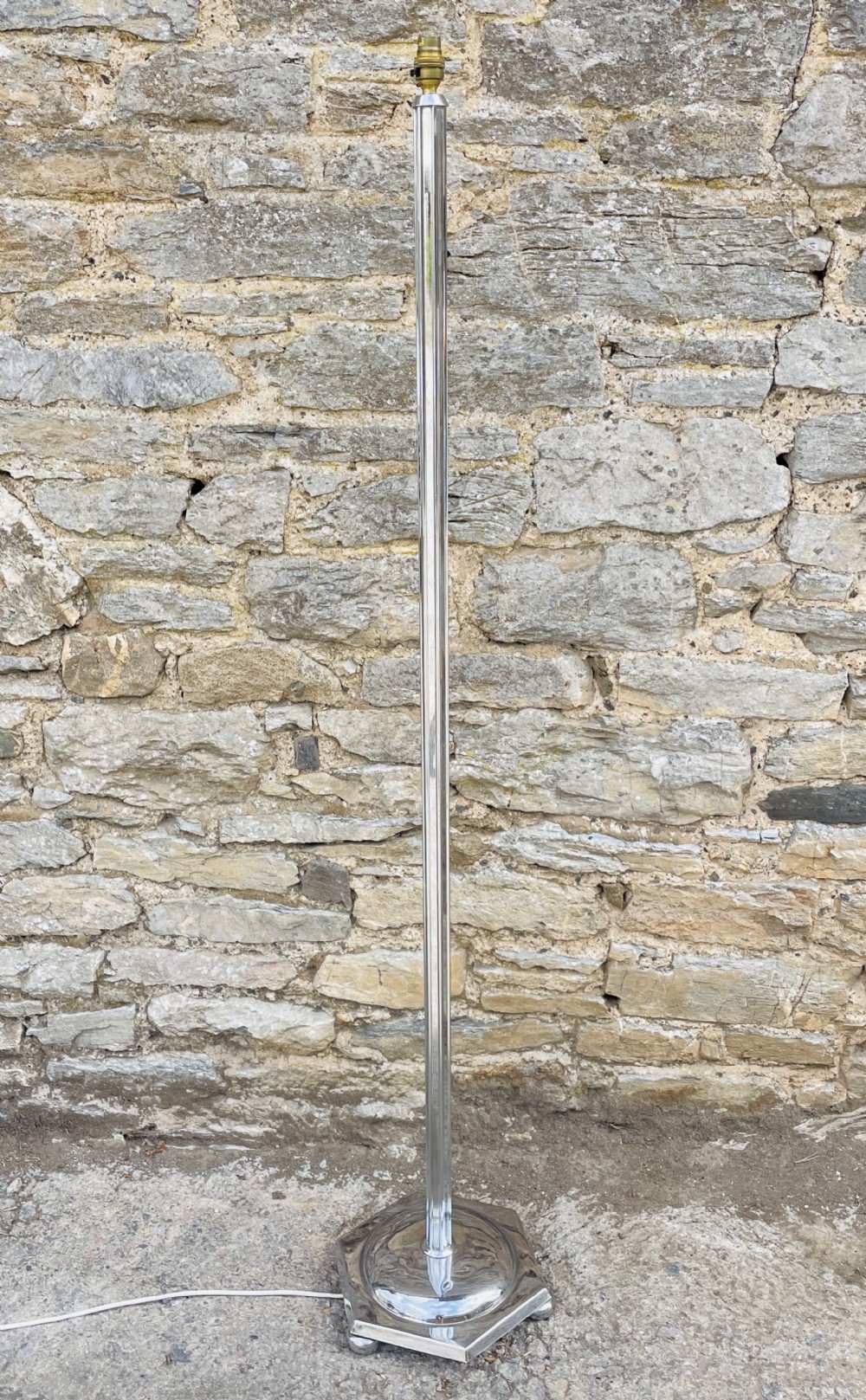 An Art Deco chrome standard lamp featuring a vertical fluted column set upon a polished hexagonal base.