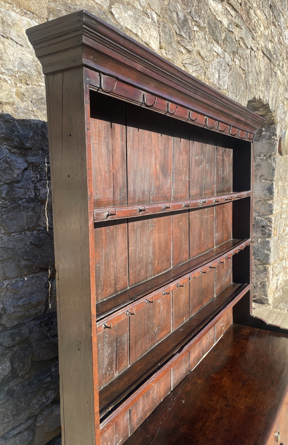 An antique dark oak Georgian dog kennel dresser featuring an open shelf rack above three drawers and two cupboard doors. View XXI