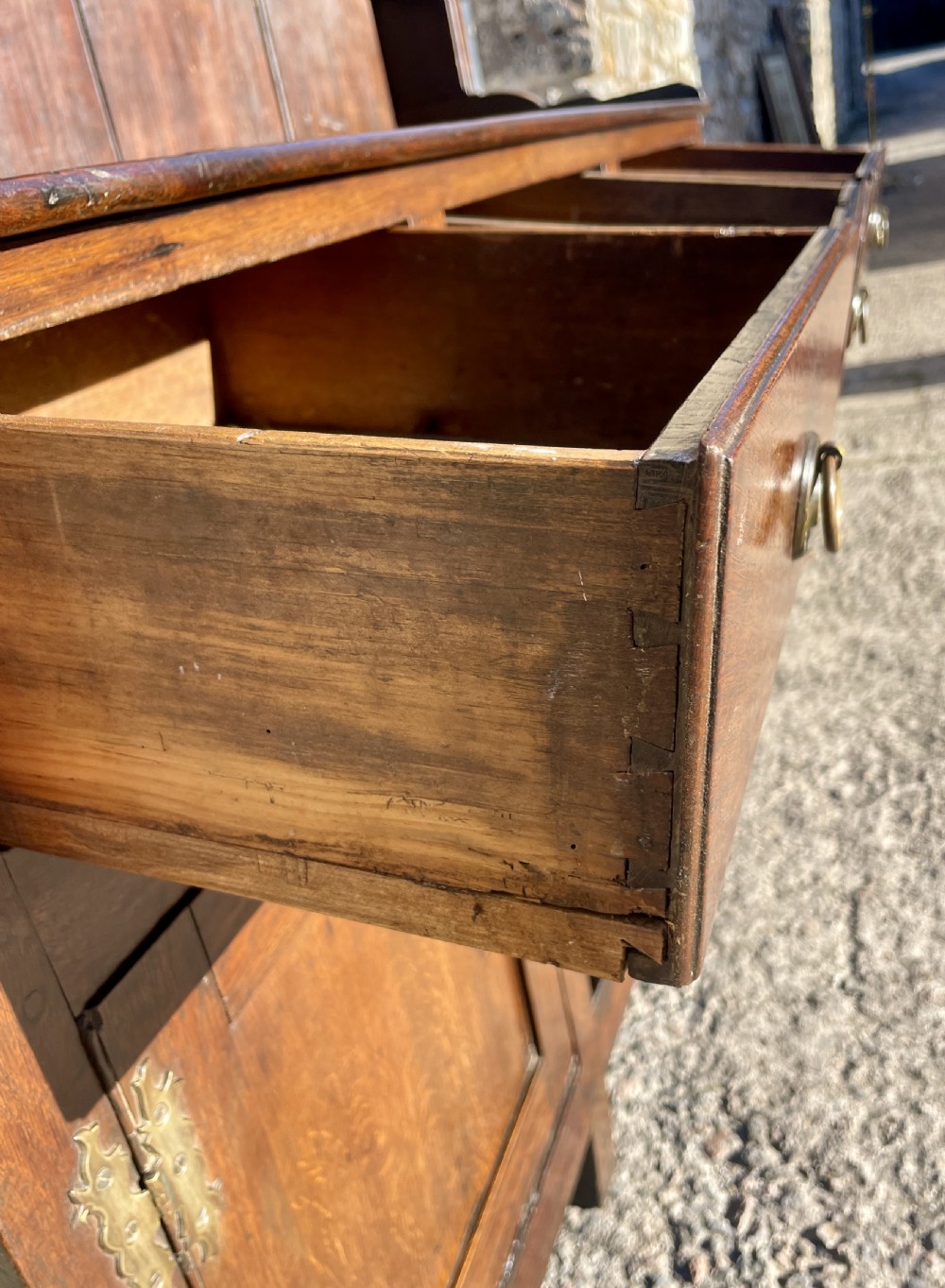 An antique dark oak Georgian dog kennel dresser featuring an open shelf rack above three drawers and two cupboard doors. View XXII