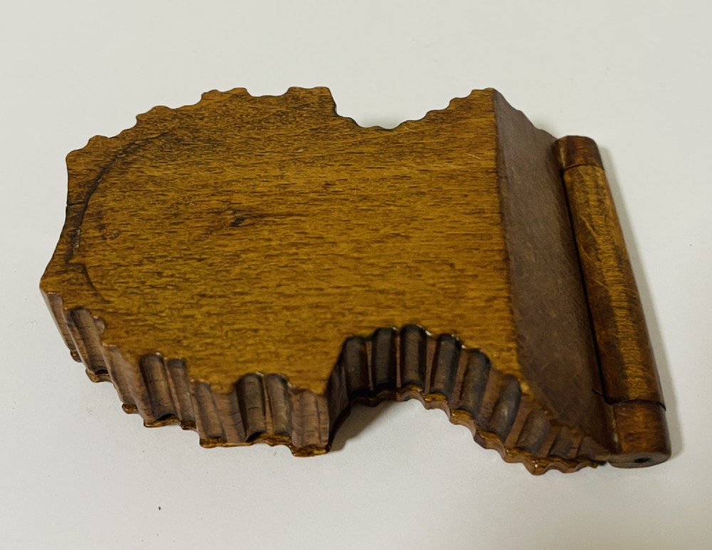 An antique carved wooden Black Forest pocket watch holder with leaf detailing on the base and a dark velvet-lined aperture for displaying a timepiece. View XIII