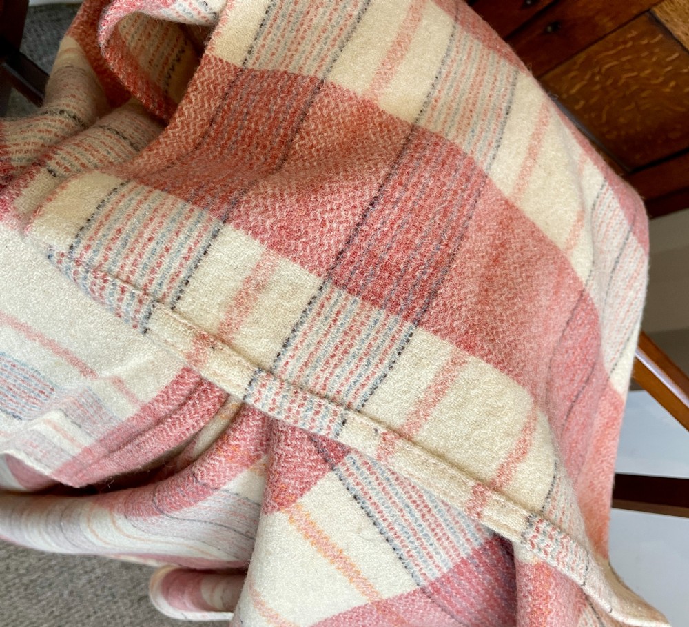 A large woven Welsh wool blanket featuring a pink, cream, and subtle yellow plaid grid design. View VII