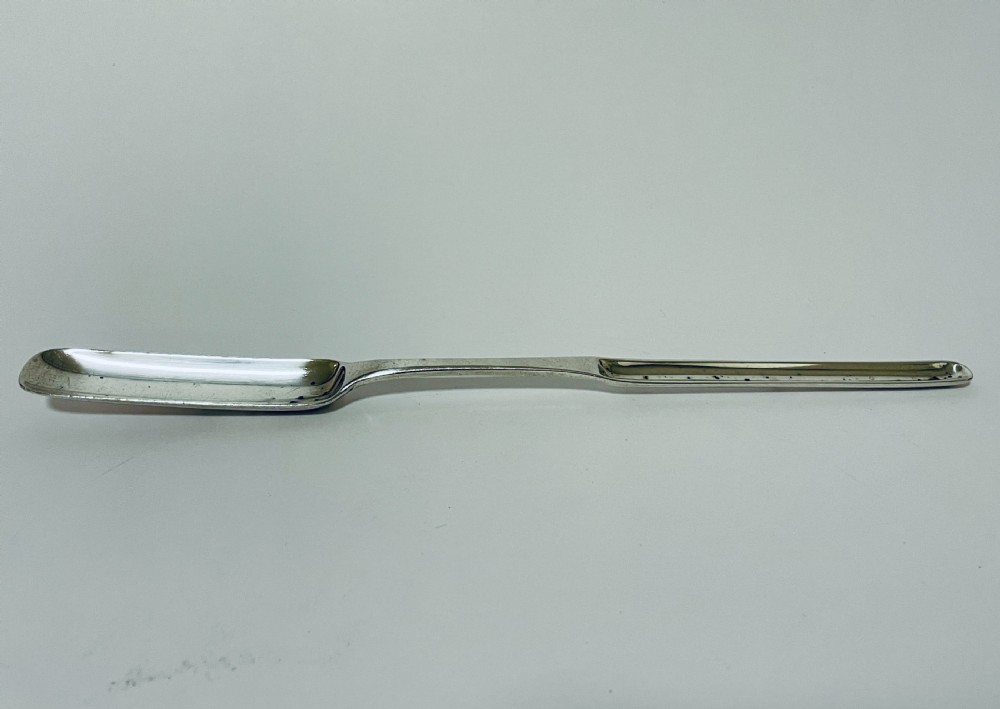 A Georgian Irish sterling silver double-ended marrow scoop resting horizontally against a plain white background. View II