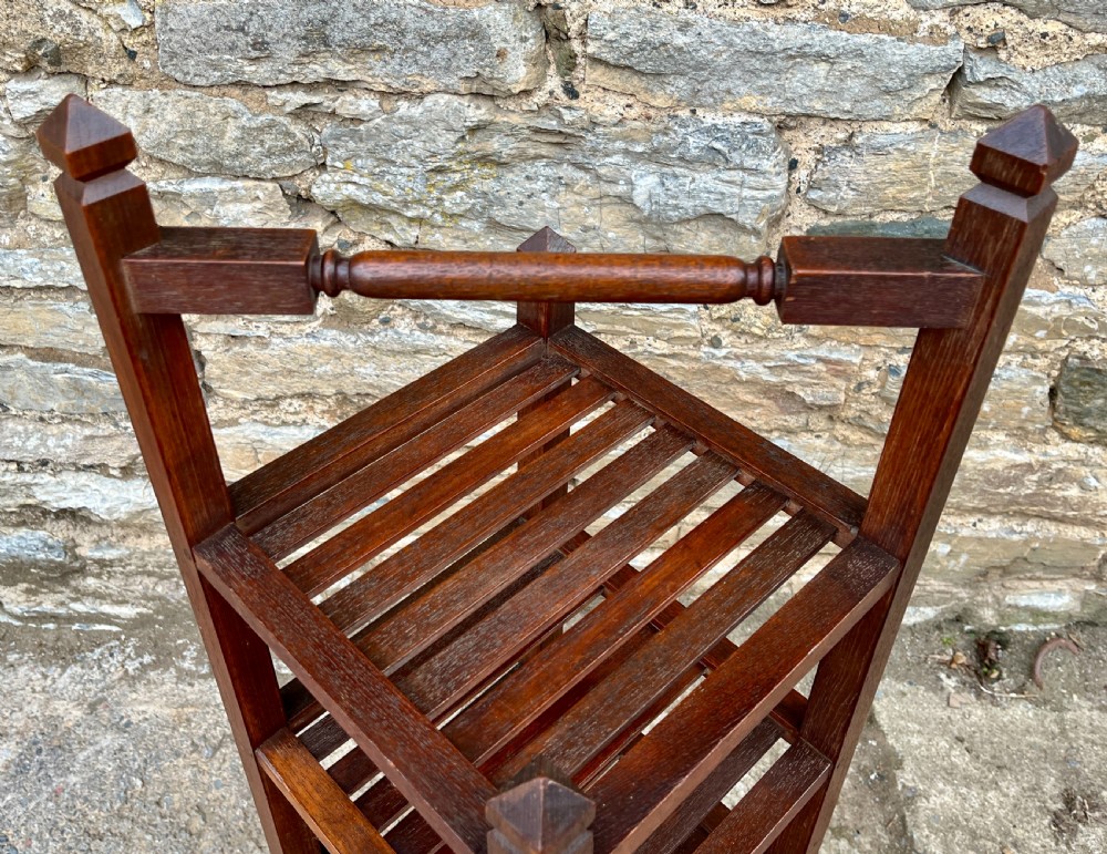 A tall, four-tier dark teak ships whatnot stand featuring slatted timber shelves, pyramid finials, a top carrying rail, and a brass makers plaque on the lowest shelf. View VII