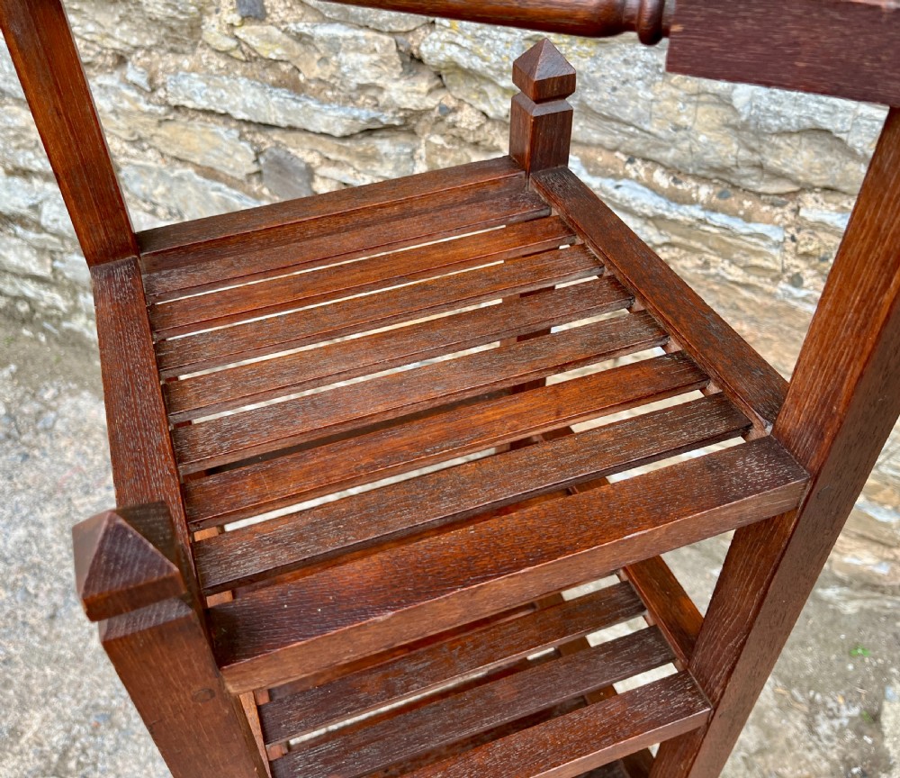 A tall, four-tier dark teak ships whatnot stand featuring slatted timber shelves, pyramid finials, a top carrying rail, and a brass makers plaque on the lowest shelf. View VIII
