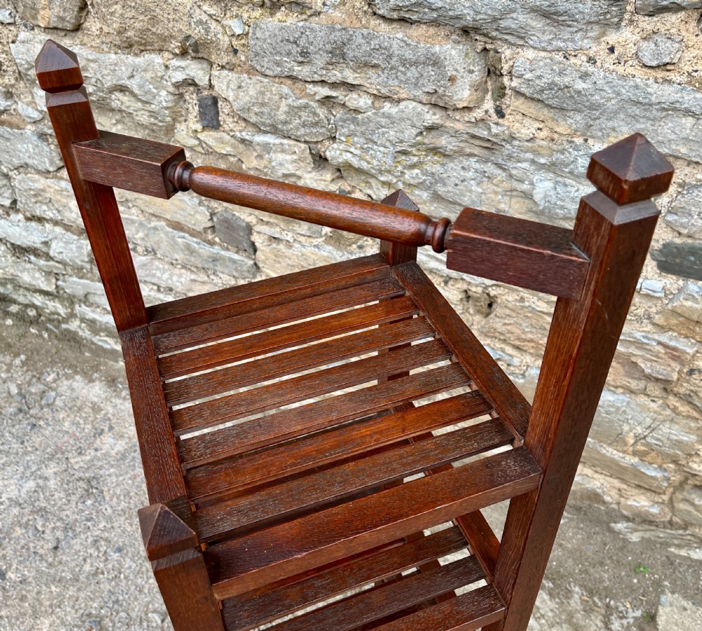 A tall, four-tier dark teak ships whatnot stand featuring slatted timber shelves, pyramid finials, a top carrying rail, and a brass makers plaque on the lowest shelf. View IX