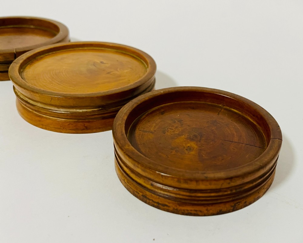 A set of three circular turned boxwood apothecary pill rounders with shallow central recesses and concentric moulded edges. View VI