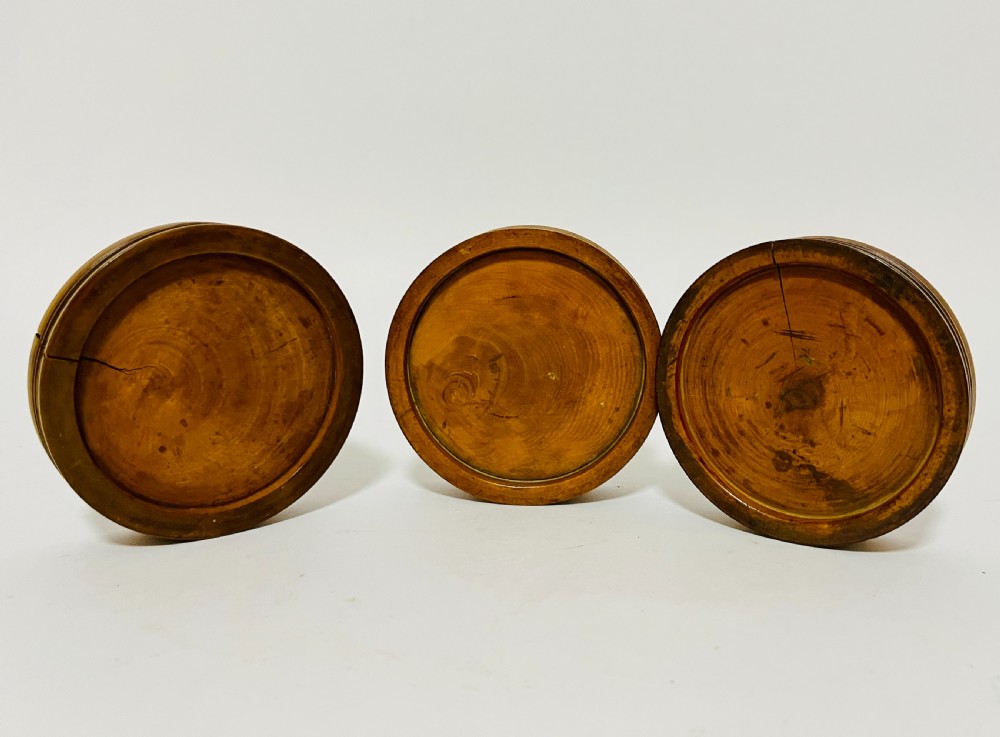 A set of three circular turned boxwood apothecary pill rounders with shallow central recesses and concentric moulded edges. View VII