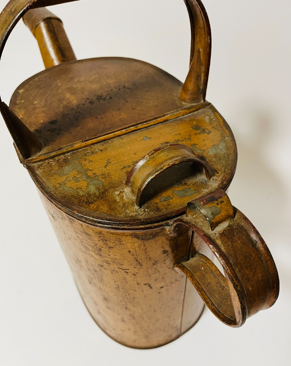 A Victorian painted tinplate hot water can featuring an overhead carrying handle, side loop handle, hinged lid, and angled spout. View V