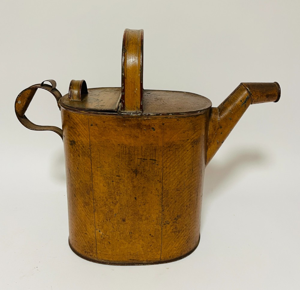 A Victorian painted tinplate hot water can featuring an overhead carrying handle, side loop handle, hinged lid, and angled spout. View IX