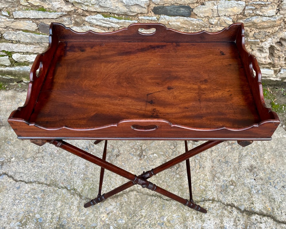 A Georgian mahogany folding butlers tray table with a scalloped gallery border, heart-shaped cut-out handles, and a turned X-frame stand. View II