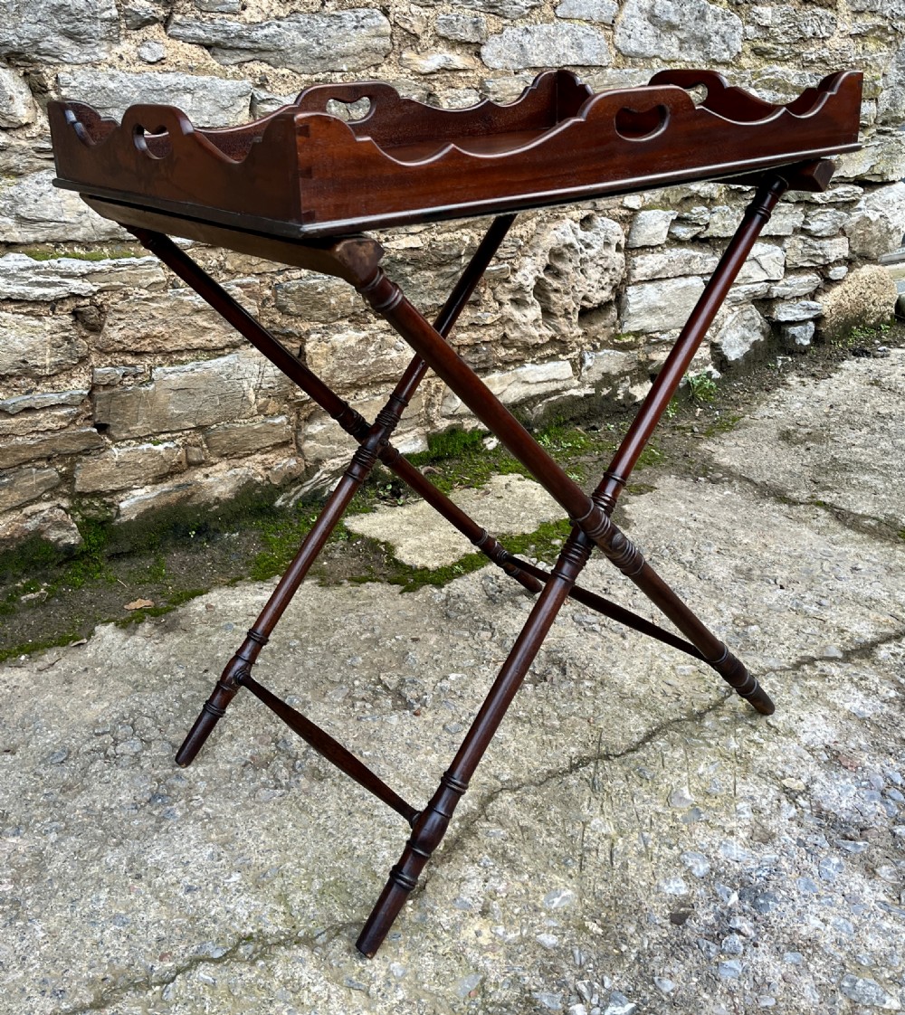 A Georgian mahogany folding butlers tray table with a scalloped gallery border, heart-shaped cut-out handles, and a turned X-frame stand. View III