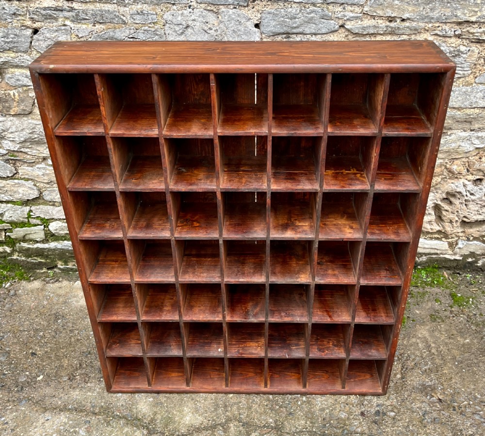 A large square wooden storage unit featuring a six-by-six grid of thirty-six rectangular cubbies made of dark stained pine. View II