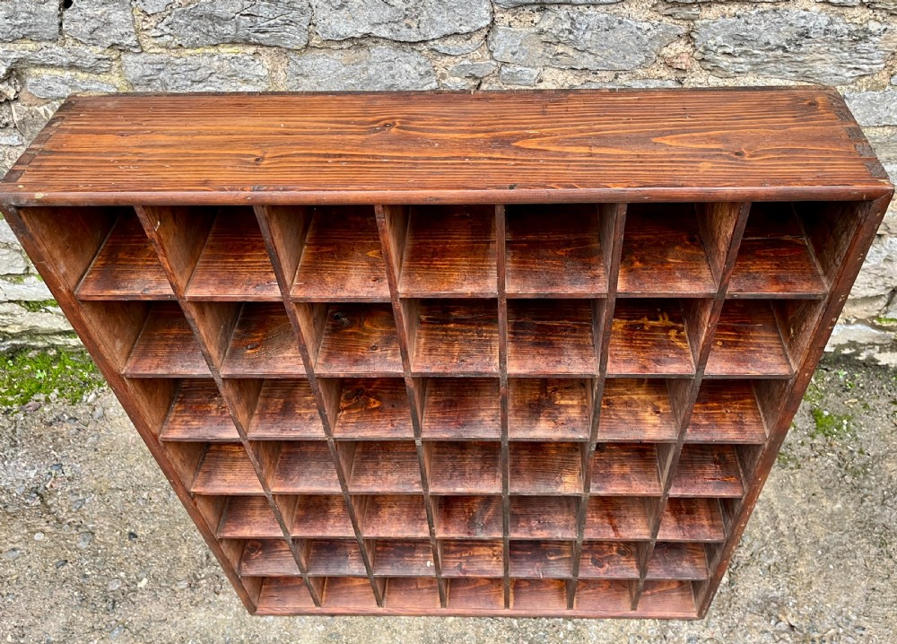 A large square wooden storage unit featuring a six-by-six grid of thirty-six rectangular cubbies made of dark stained pine. View V