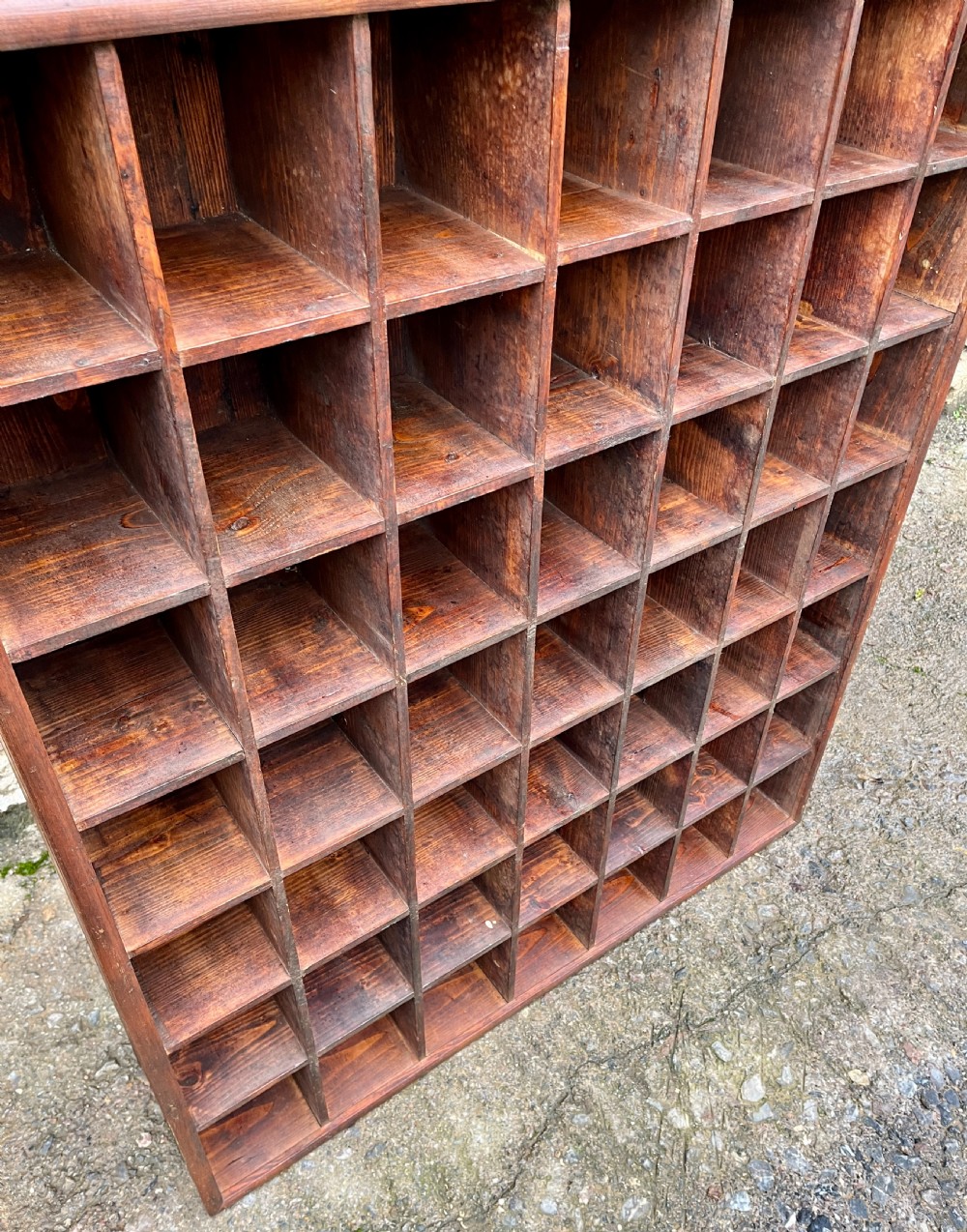 A large square wooden storage unit featuring a six-by-six grid of thirty-six rectangular cubbies made of dark stained pine. View VI