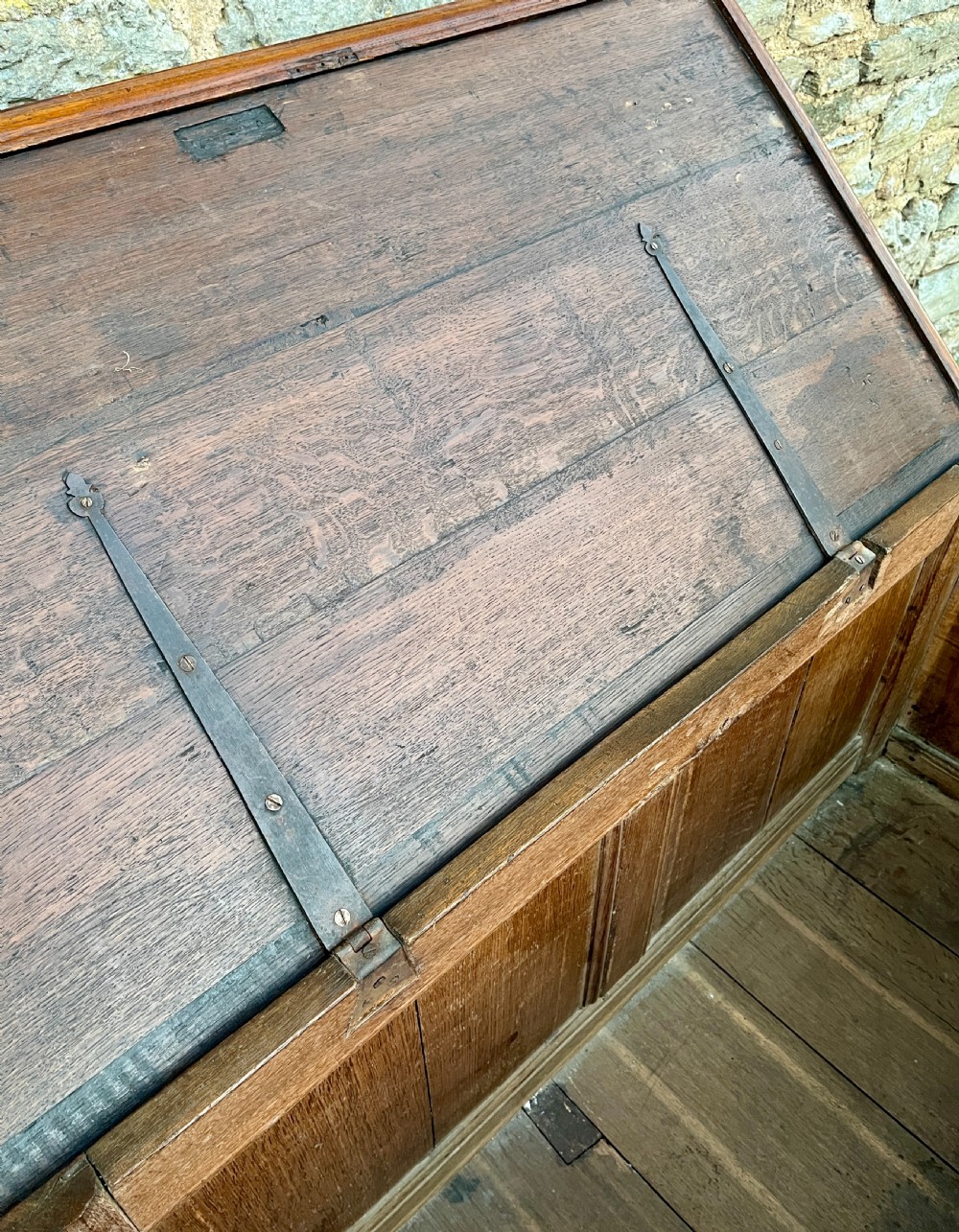 A solid oak blanket chest featuring dual fielded front panels, a central brass keyhole escutcheon, and a carved decorative apron along the base. View IX