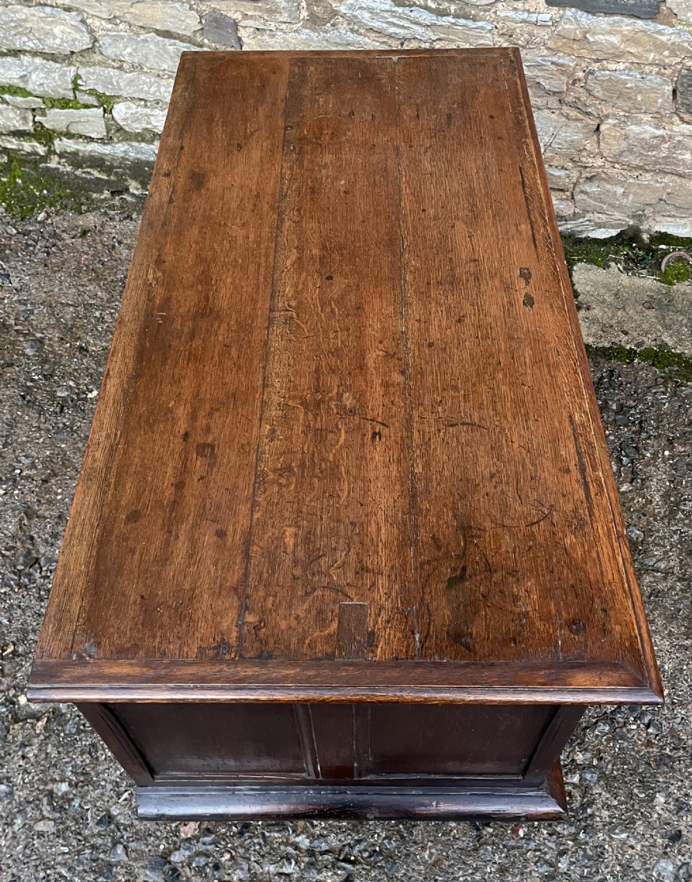A solid oak blanket chest featuring dual fielded front panels, a central brass keyhole escutcheon, and a carved decorative apron along the base. View XV