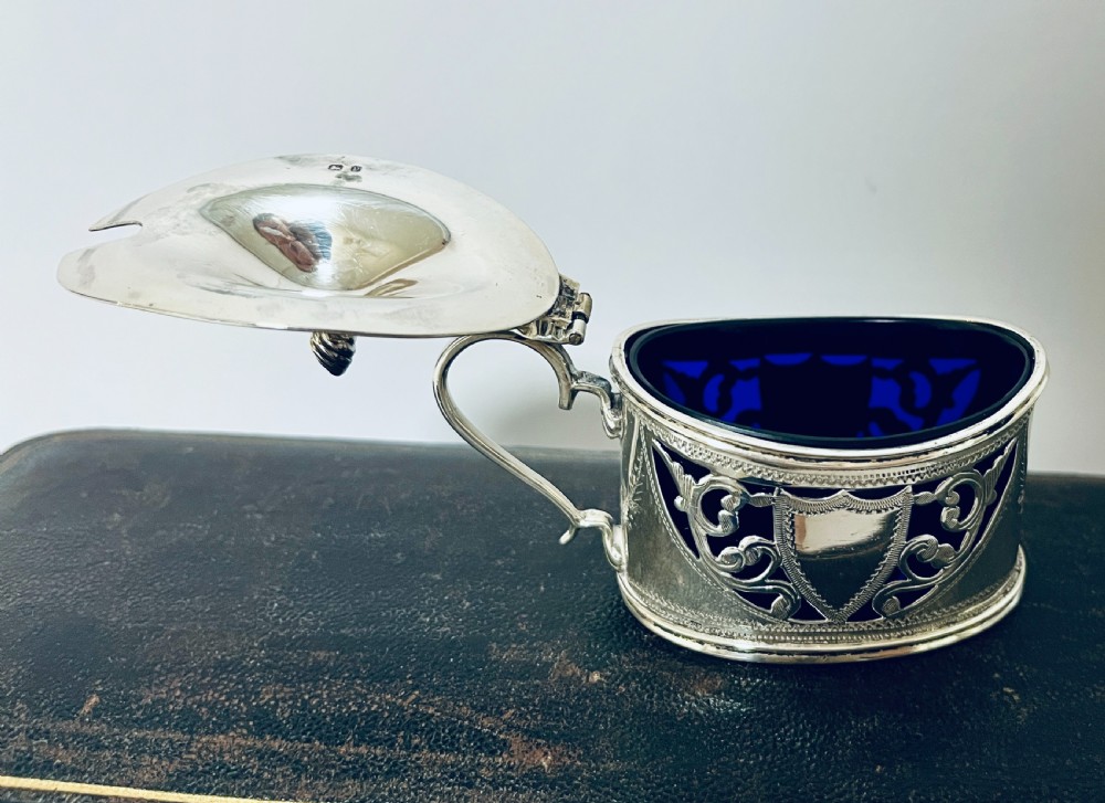 A three-piece Victorian silver condiment set with matching spoons displayed inside a fitted blue satin-lined dark presentation case. View VII