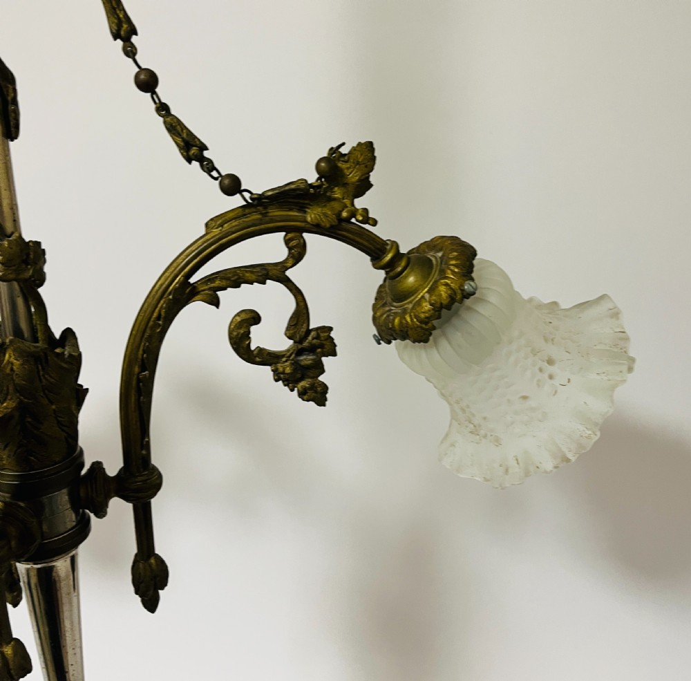 A French Empire style bronze chandelier featuring three ornate scrolling arms with frosted glass ruffled shades and hanging chain details. View VIII