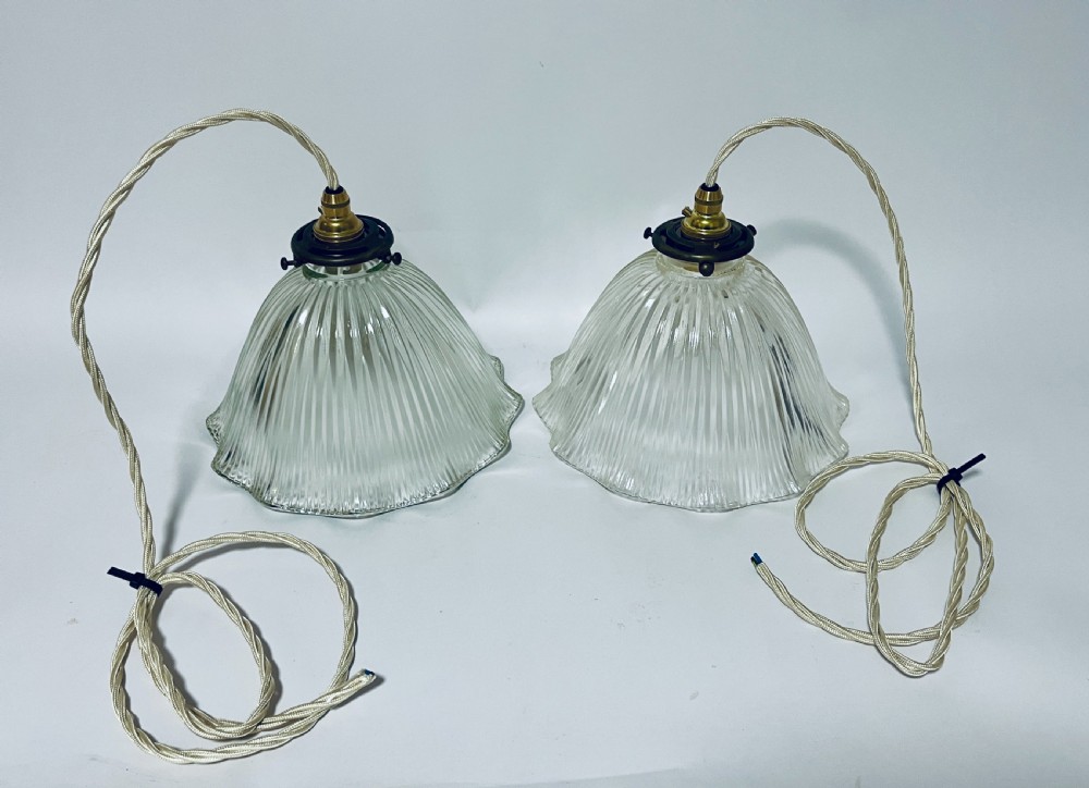 A pair of clear ribbed prismatic glass pendant light shades fitted with brass collars and light braided flex cords. View IV