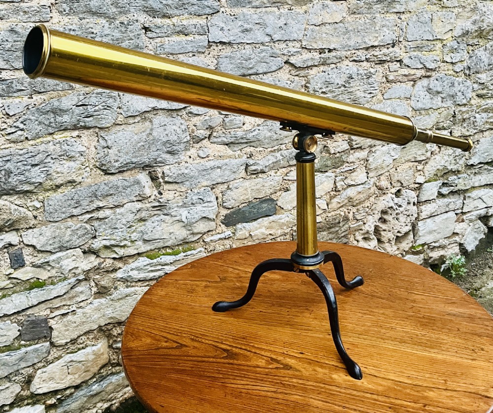 A Victorian brass library telescope supported by a black cast iron tripod desktop base. View II