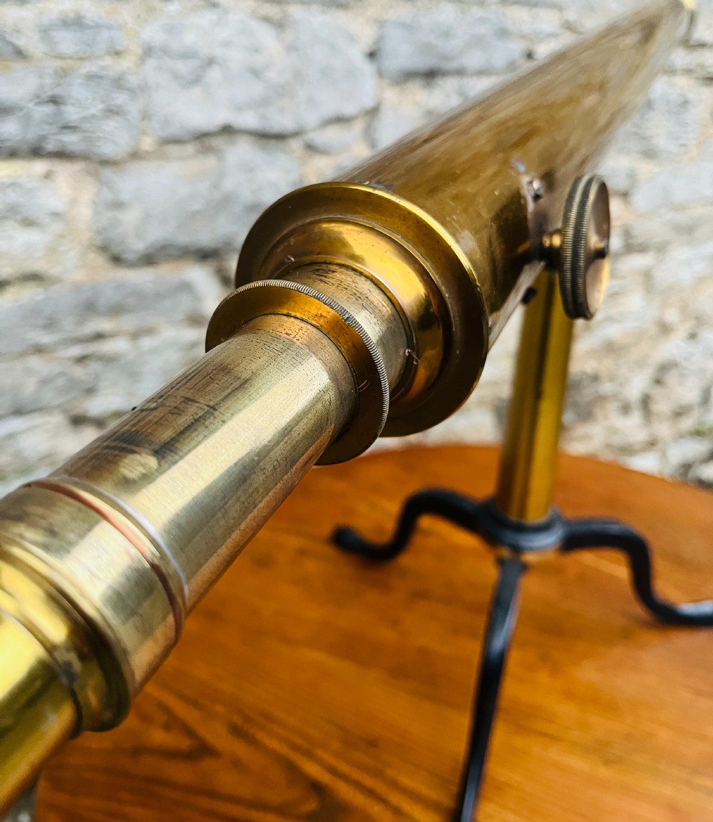 A Victorian brass library telescope supported by a black cast iron tripod desktop base. View III