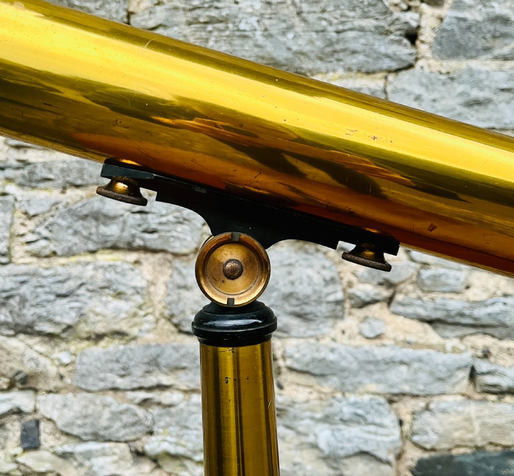 A Victorian brass library telescope supported by a black cast iron tripod desktop base. View VI