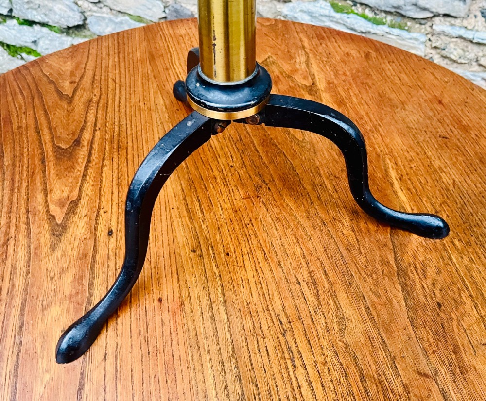A Victorian brass library telescope supported by a black cast iron tripod desktop base. View VII