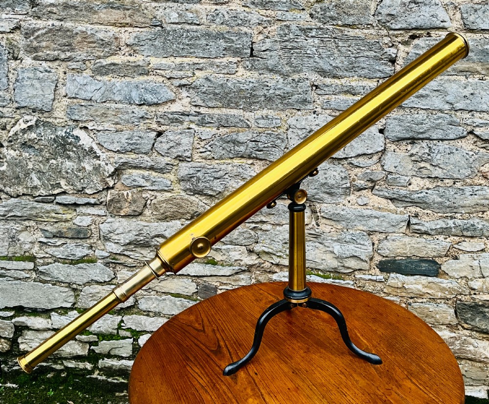 A Victorian brass library telescope supported by a black cast iron tripod desktop base. View VIII