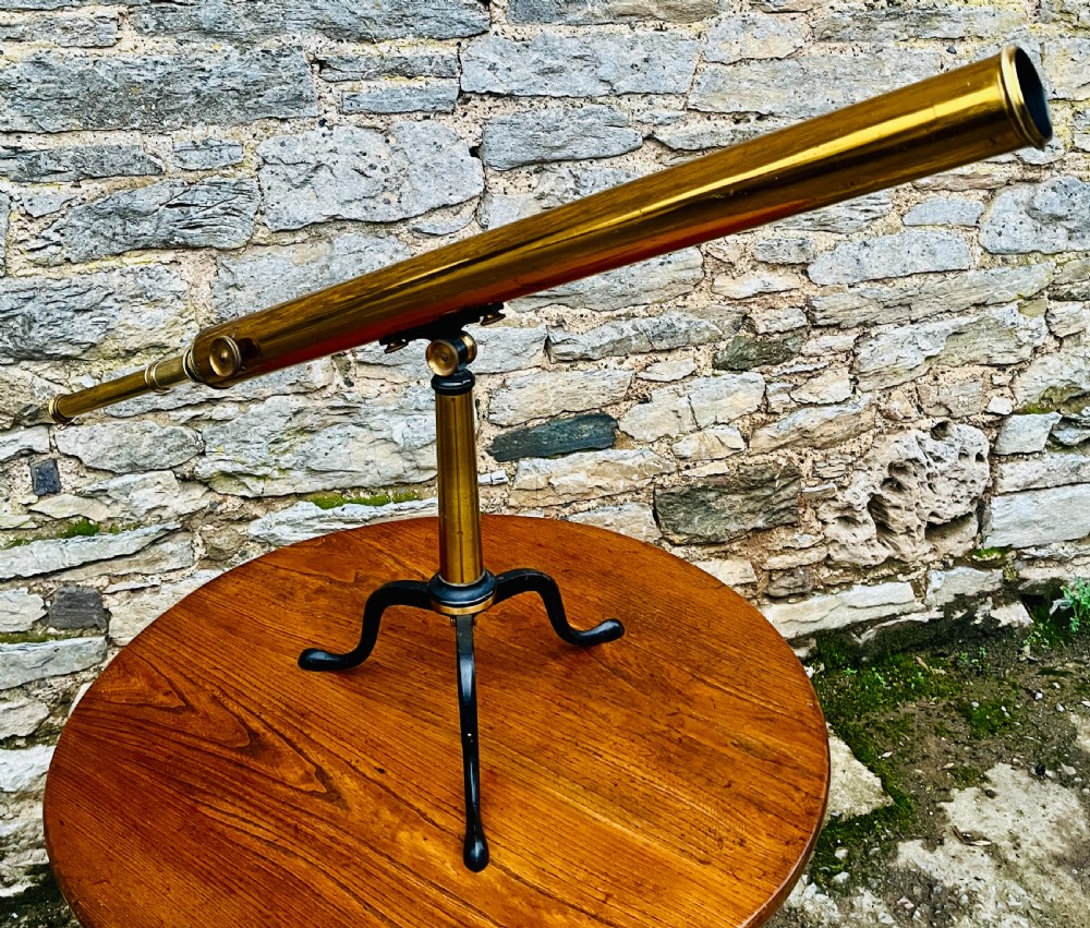 A Victorian brass library telescope supported by a black cast iron tripod desktop base. View XI