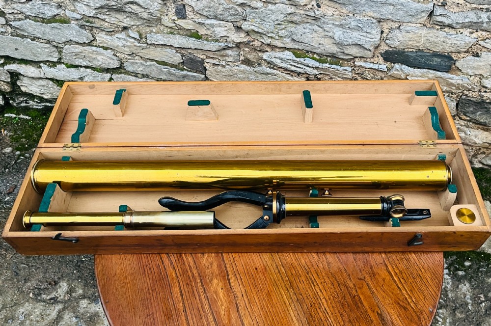 A Victorian brass library telescope supported by a black cast iron tripod desktop base. View XII