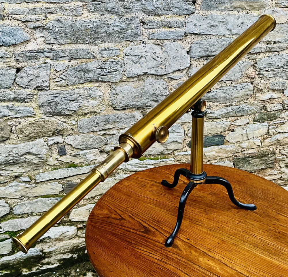 A Victorian brass library telescope supported by a black cast iron tripod desktop base. View XV
