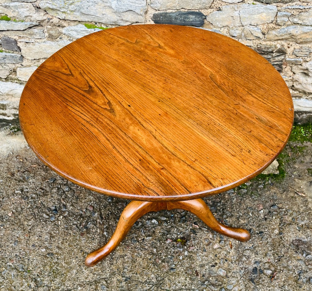 A circular Georgian oak tilt-top table resting on a central turned pedestal with three sweeping tripod legs. View II