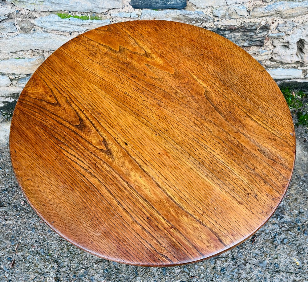A circular Georgian oak tilt-top table resting on a central turned pedestal with three sweeping tripod legs. View III
