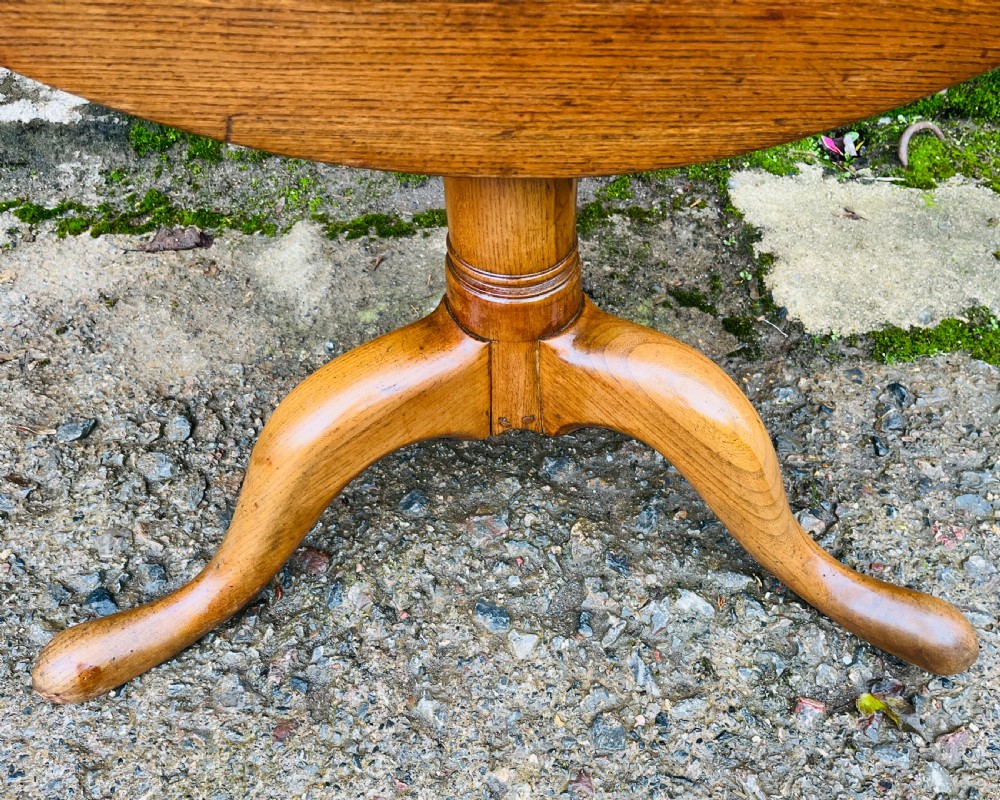 A circular Georgian oak tilt-top table resting on a central turned pedestal with three sweeping tripod legs. View IV
