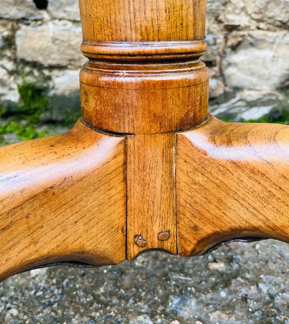 A circular Georgian oak tilt-top table resting on a central turned pedestal with three sweeping tripod legs. View V