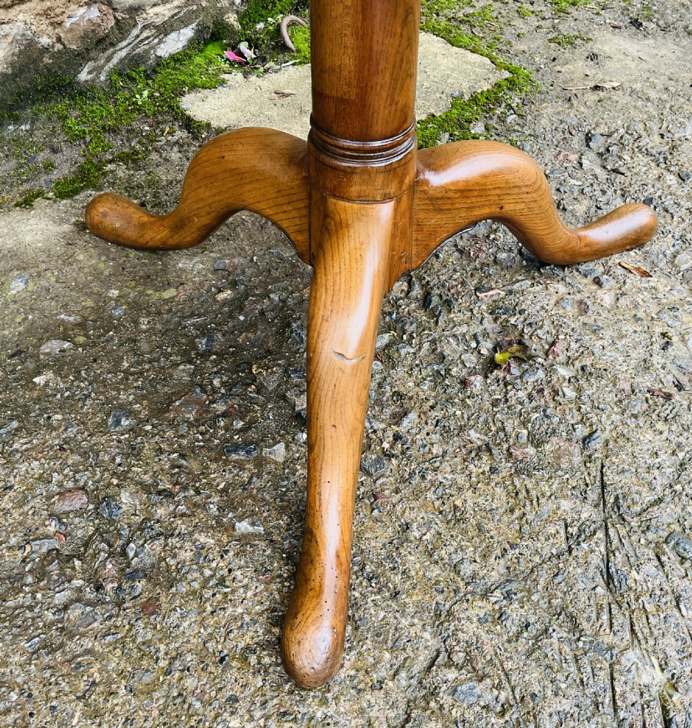 A circular Georgian oak tilt-top table resting on a central turned pedestal with three sweeping tripod legs. View VIII