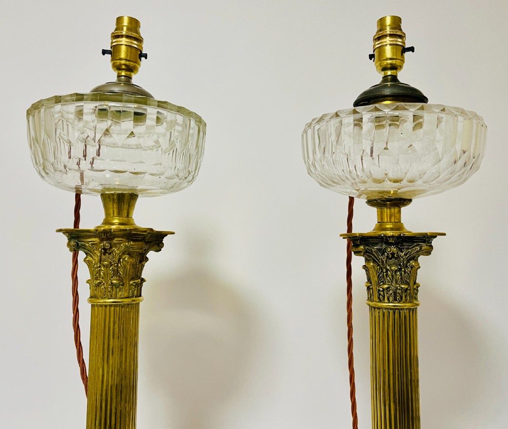 A pair of brass Corinthian column table lamps featuring stepped square plinths, fluted columns, acanthus capitals, and cut glass reservoirs. View III
