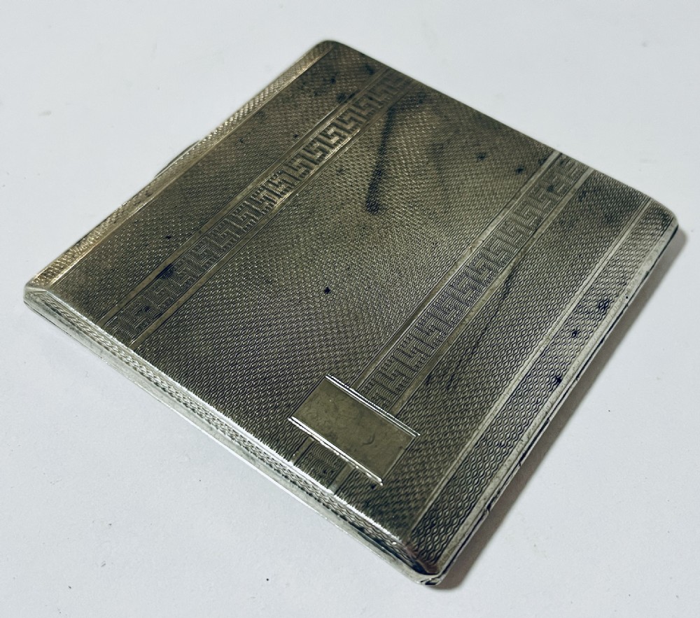 An Art Deco silver rectangular cigarette case featuring engine-turned geometric patterning and a small rectangular vacant cartouche. View III