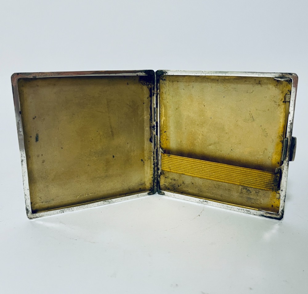 An Art Deco silver rectangular cigarette case featuring engine-turned geometric patterning and a small rectangular vacant cartouche. View V