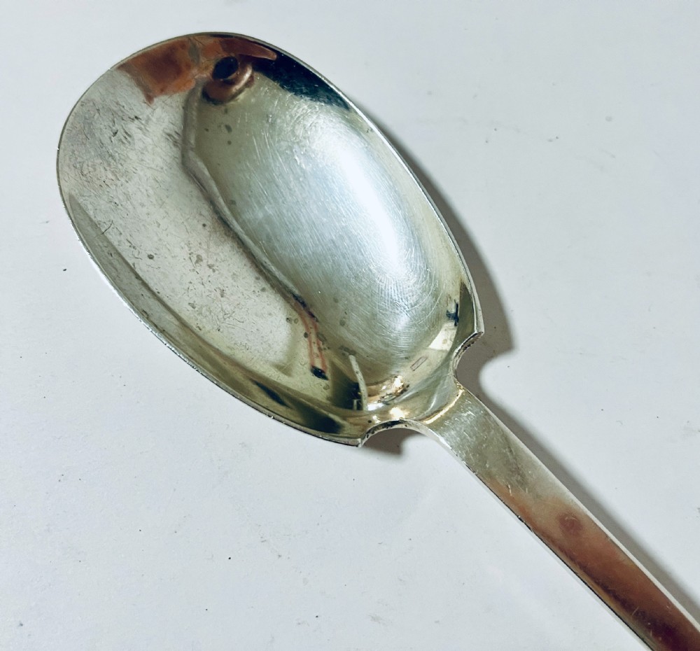 A silver seal top spoon featuring a wide oval bowl, straight stem, and a flat seal terminal. View V
