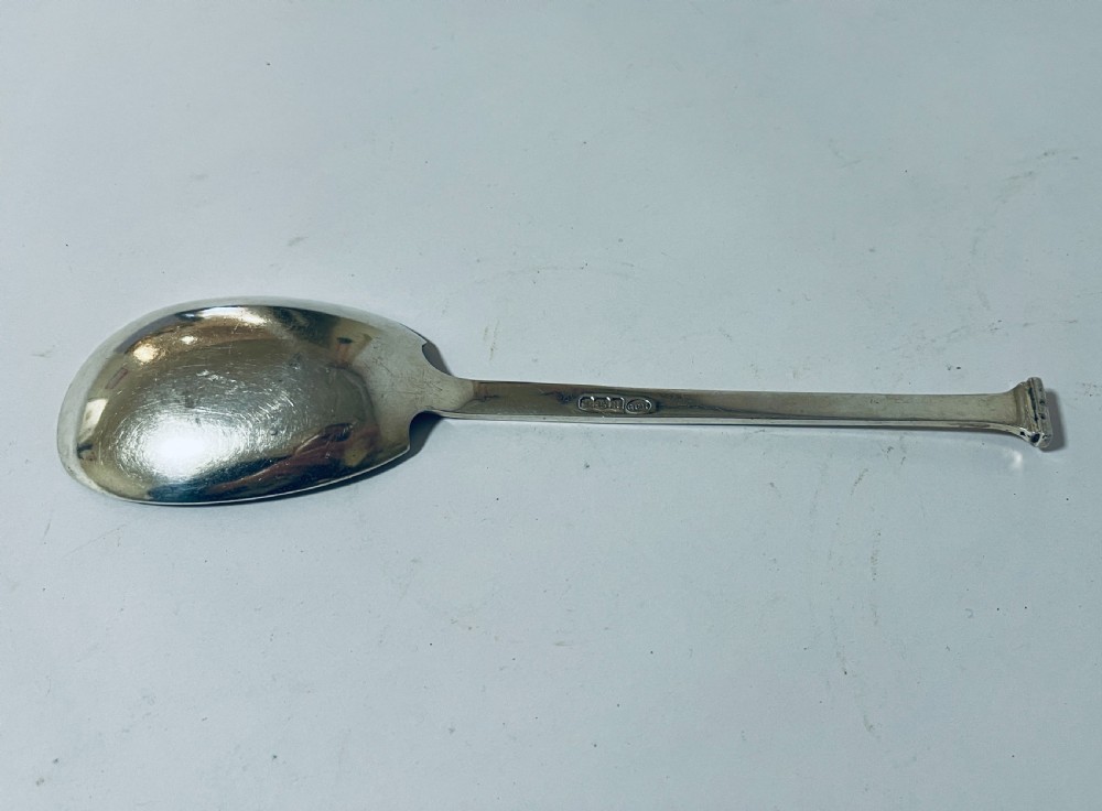 A silver seal top spoon featuring a wide oval bowl, straight stem, and a flat seal terminal. View VI