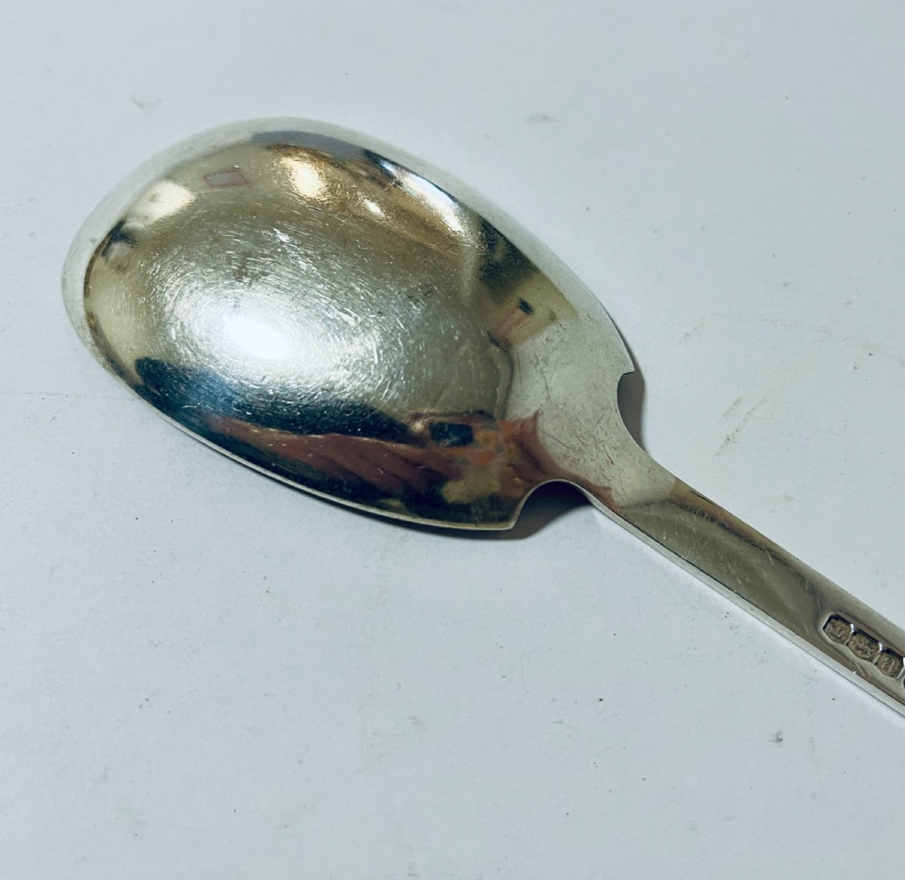 A silver seal top spoon featuring a wide oval bowl, straight stem, and a flat seal terminal. View VII