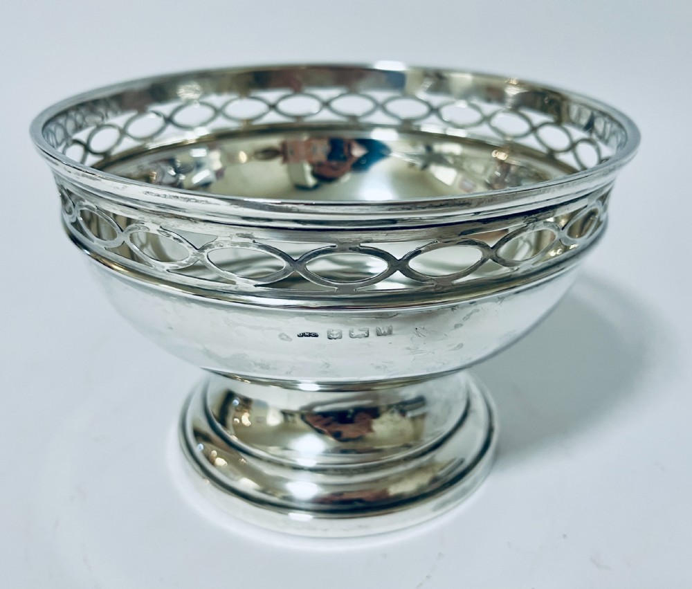 A polished silver pedestal rose bowl featuring a pierced rim with an interlocking oval gallery pattern. View III