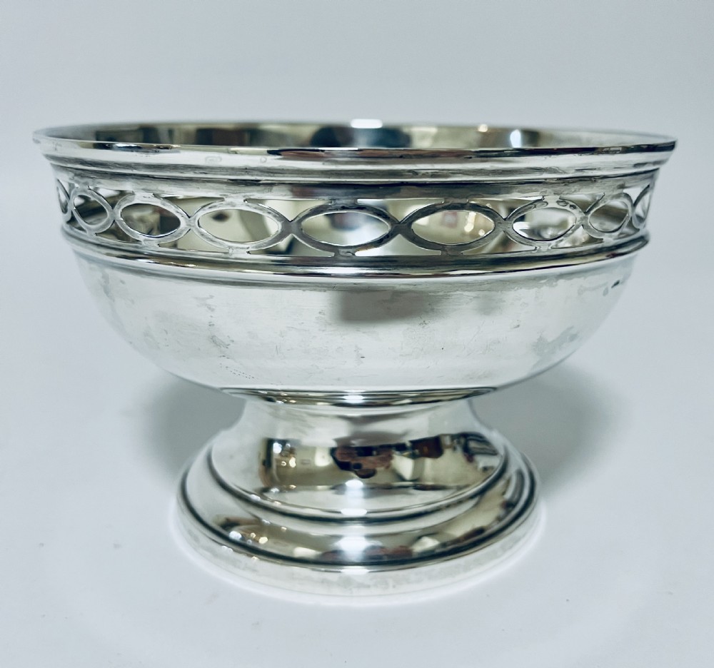 A polished silver pedestal rose bowl featuring a pierced rim with an interlocking oval gallery pattern. View VII