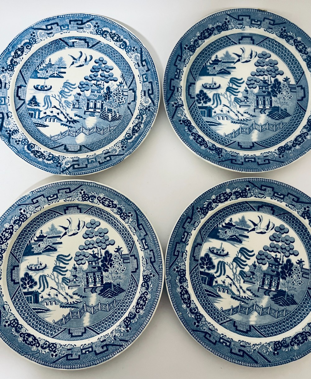 A set of six circular earthenware plates decorated with classic cobalt blue and white Willow Pattern transferware illustrations. View V