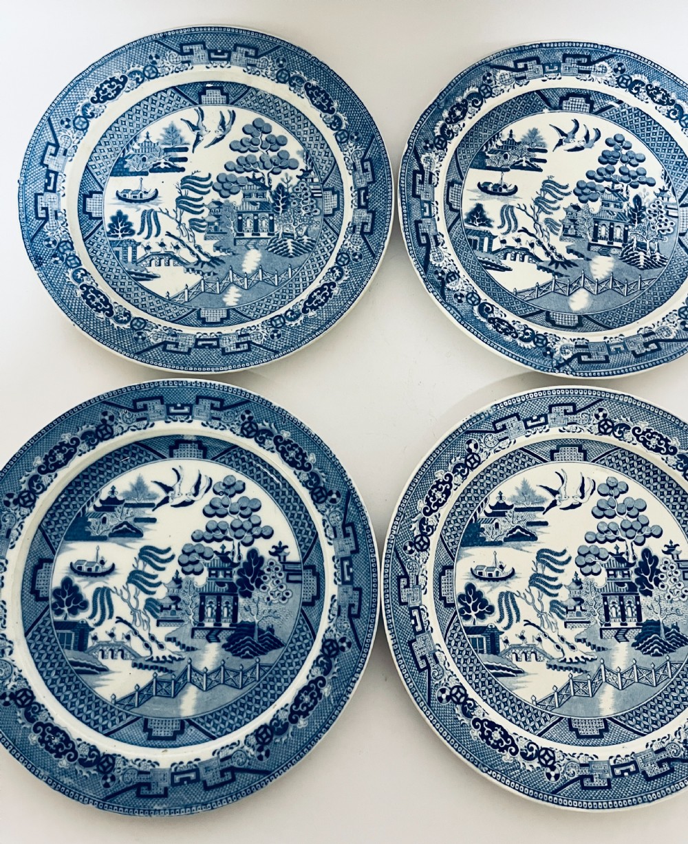 A set of six circular earthenware plates decorated with classic cobalt blue and white Willow Pattern transferware illustrations. View VI