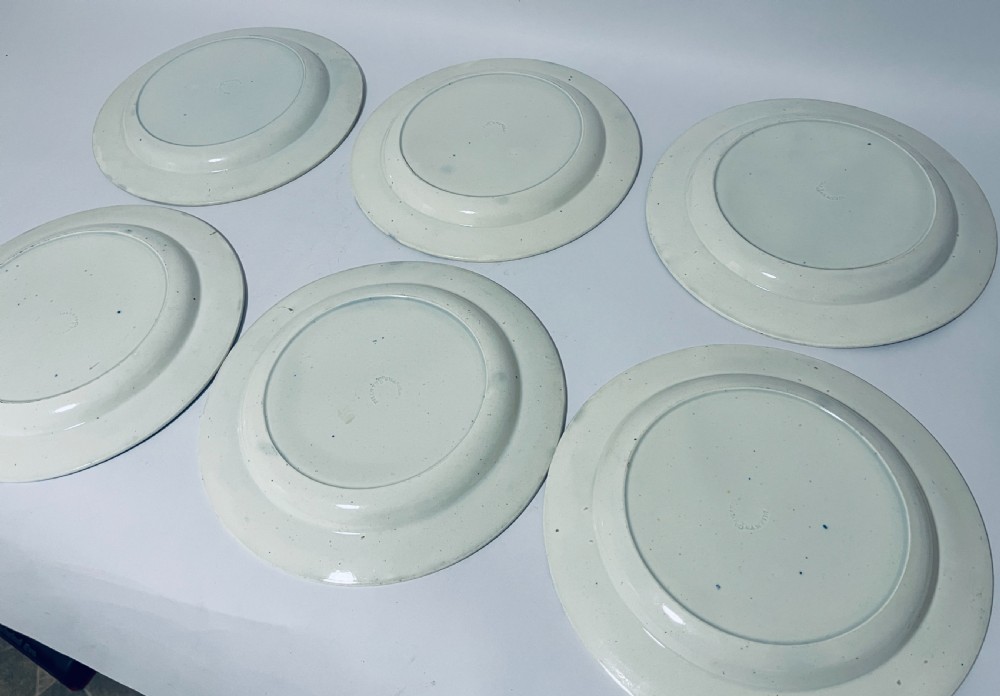 A set of six circular earthenware plates decorated with classic cobalt blue and white Willow Pattern transferware illustrations. View VII