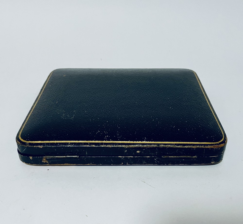 A set of six Victorian silver-handled butter knives with chased foliate handles, resting inside an open dark blue silk-lined presentation box. View XII