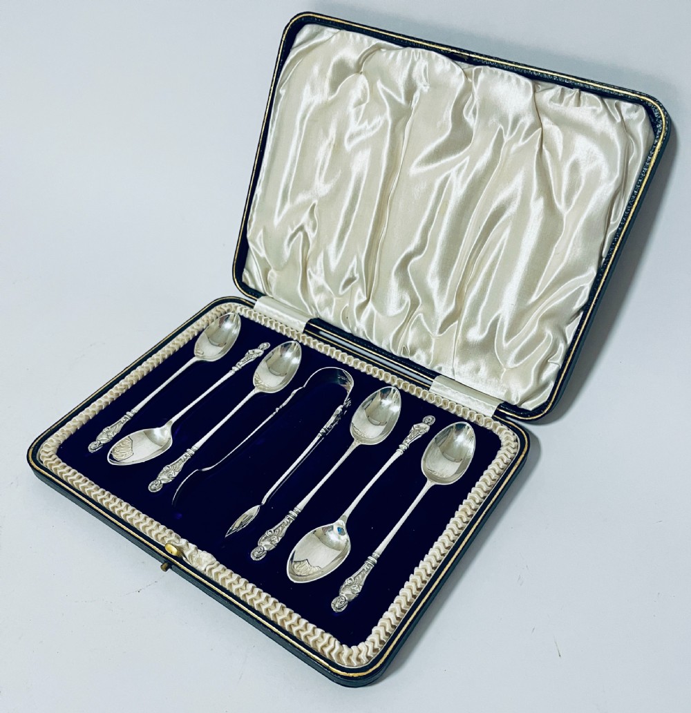 A cased set of six silver teaspoons and matching sugar tongs arranged in a blue velvet lined presentation box with cream satin lid. View III